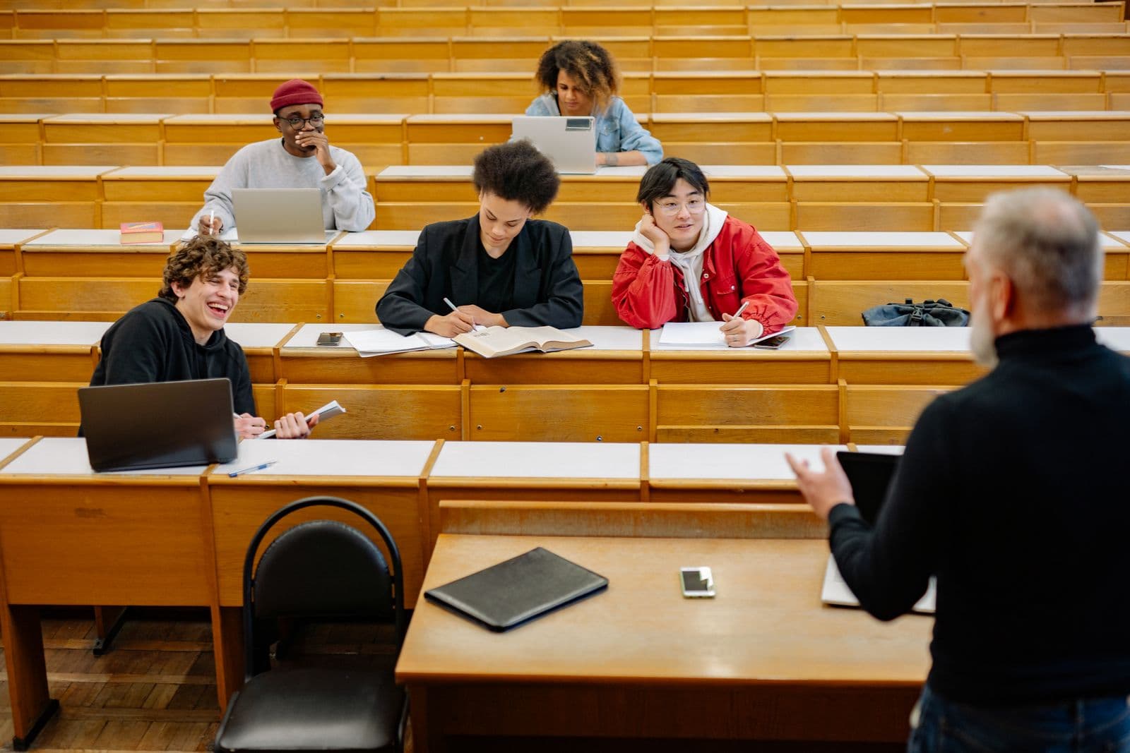Lecturer teaching students in a tiered lecture hall
